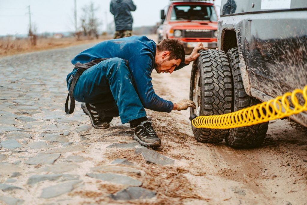 man pumps air wheel with compressor